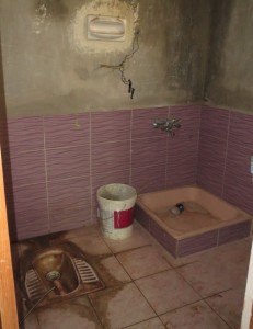 This is the bathroom for three refugee families in a basement apartment. The device at bottom left is the toilet.