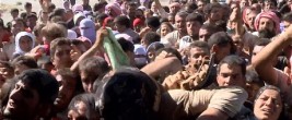Iraqis rush helicopter for food and aid on a desolate mountaintop.