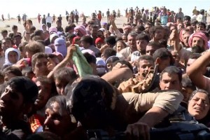 Iraqis rush helicopter for food and aid on a desolate mountaintop.