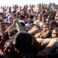 Iraqis rush helicopter for food and aid on a desolate mountaintop.