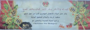 A large banner proclaiming Luke 2:14 “Glory to God in the highest, and on earth peace, good will toward men.” at a Christmas for Refugees event in Iraq. 