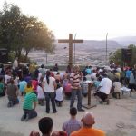 As Christian youth sing the Cross is before them. Behind the Cross on the other side of the Jordan Valley is Israel