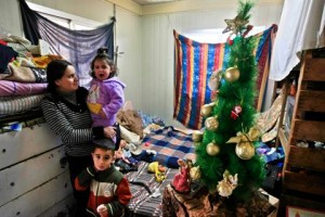 Lara Qaloumi and her children gather around a Christmas tree at their shelter home in Maghdouche, east of Sidon, Tuesday, Dec. 24, 2013. (The Daily Star)