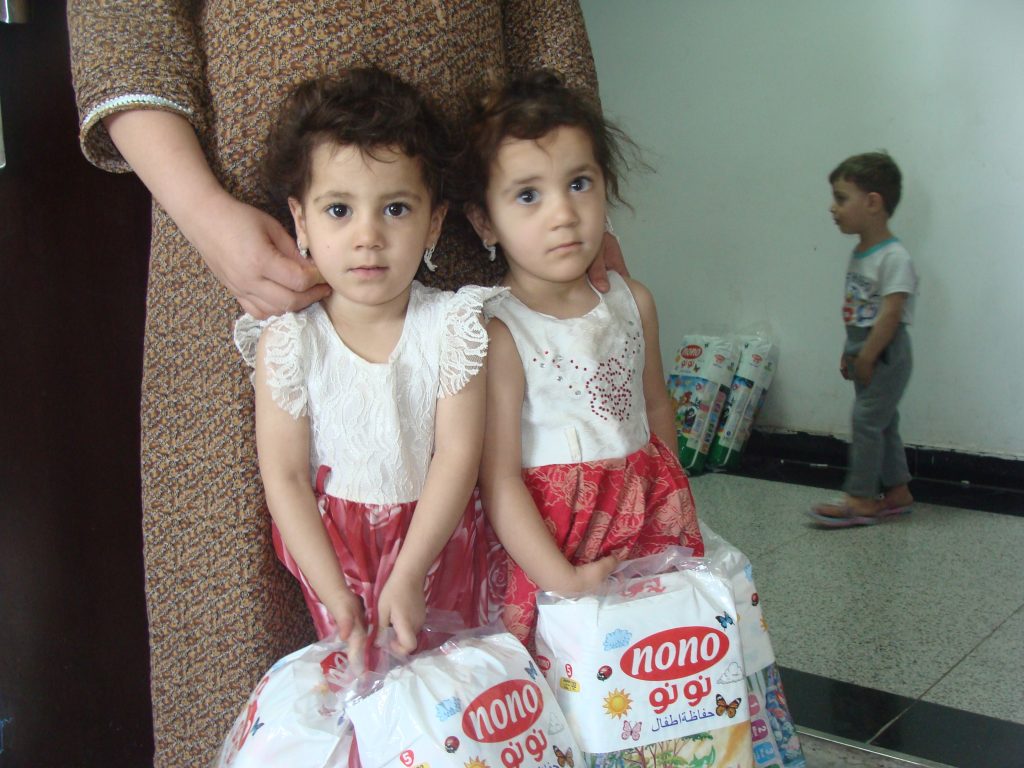 Girls hold diapers distributed by our Diapers for Refugees program