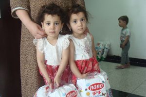 Girls hold diapers distributed by our Diapers for Refugees program