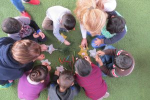 A small group of children make star ornaments as a project during a Christmas for Refugees event at a Nazarene Church in Lebanon. Christmas, 2017